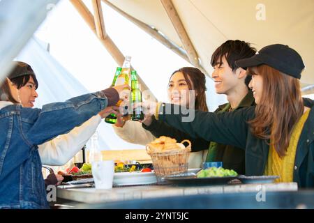 Mann und Frau in ihren 20ern, die einen Toast über das Essen machen Stockfoto