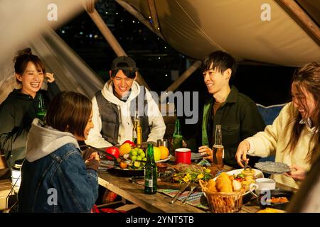Mann und Frau in ihren 20ern, die draußen essen Stockfoto