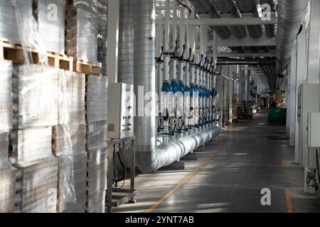 Durchgang zwischen Gewächshäusern mit Verpackungslager und Heizung, Wasserleitungssystem und Sicherungskasten Stockfoto