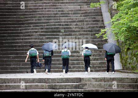 Junior High School Schüler mit Regenschirmen Stockfoto