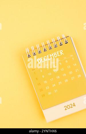Gelber Desktop-Kalender für Dezember 2024 auf gelbem Hintergrund. Stockfoto