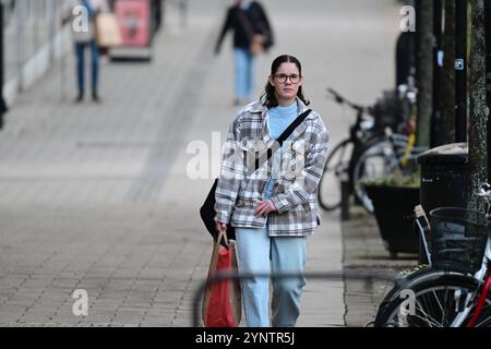 Hässleholm, Skåne, Schweden. November 2024. Frau auf der Straße. Stockfoto