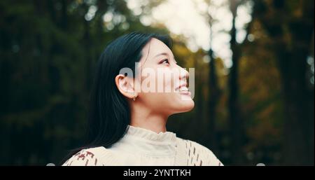 Japanische Frau, die denkt und draußen mit Lächeln, Selbstvertrauen oder Stolz im Garten oder Park. Weibliche Person, Glück und Biologiestudentin an der Universität für Stockfoto