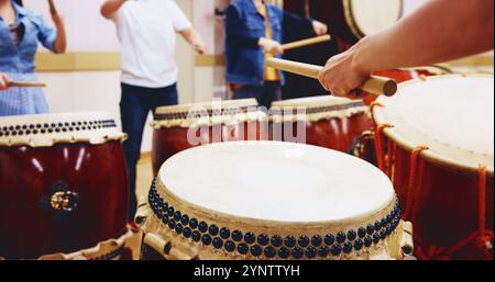 Japanische Trommeln, Hände und Leute mit Stangen am Instrument für Bühnenübungen, Auftritte oder Talent. Taiko, Klasse und Schlagzeuger in der Band Stockfoto