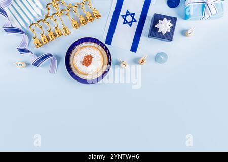 Traditionelle Leckereien und Symbole des jüdischen Feiertags von Hanukka in blauer weißer Farbe auf blauem Hintergrund. Draufsicht. Oberer Rand. Platz für Ihren Text Stockfoto