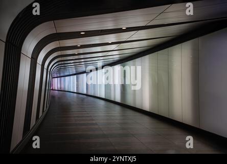 London, Großbritannien - 18. Oktober 2023 - farbenfrohe, ständig wechselnde Beleuchtung am modernen Fußweg unter der Kings Cross Station in London. Unterirdische Fußgängerzone Stockfoto