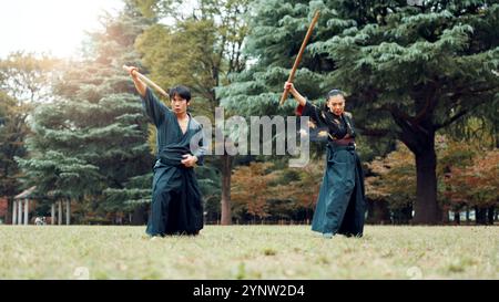 Schwert, Kampfkunst und Menschen im Outdoor-Training zusammen für Aikido, Kampftraining oder Samurai-Challenge in der Natur. Krieger, japanischer Mann und Frau Stockfoto