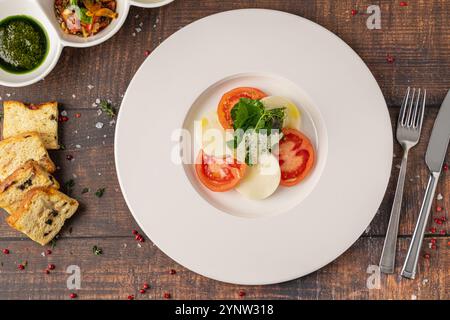 Tomaten- und Mozzarella-Salat auf einem weißen Porzellanteller, Caprese-Salat Stockfoto