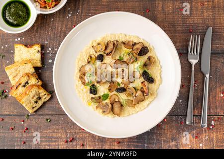 Stachelpilz-Risotto auf einer weißen Porzellanplatte, Risotto Ai funghi Stachelpilz Stockfoto