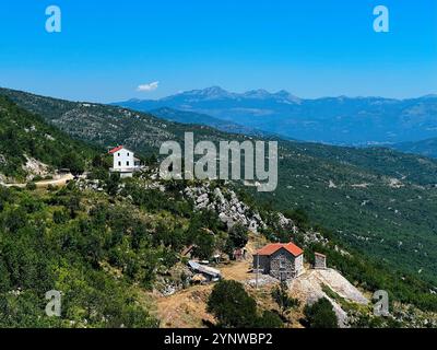 Eine malerische Berglandschaft mit zwei malerischen Häusern mit roten Dächern, eingebettet in Grün. Slansko Lake, in der Nähe von Niksic, Montenegro. Stockfoto