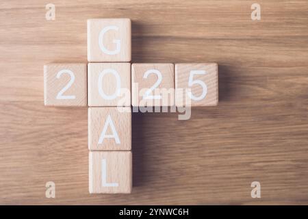 Holzblöcke stehen für das „TOR 2025“, das auf einem Tisch in einer Perspektive von oben angeordnet ist und klare Ziele und Ziele für das kommende Jahr symbolisiert. Stockfoto