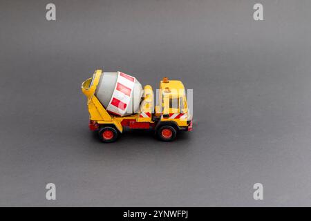 Gelbes Zementmischer-Lkw-Modell auf grauem Hintergrund mit Kopierraum für Text Stockfoto