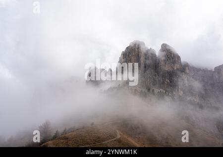 Nebelige Bedingungen auf dem Gardenapass, mit einem Pfad, der zu einer stimmungsvollen Berglandschaft führt Stockfoto