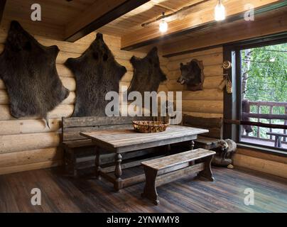 Das Innere des Jägerhauses mit den Fellen von Wildschweinen, die an den Wänden hängen Stockfoto