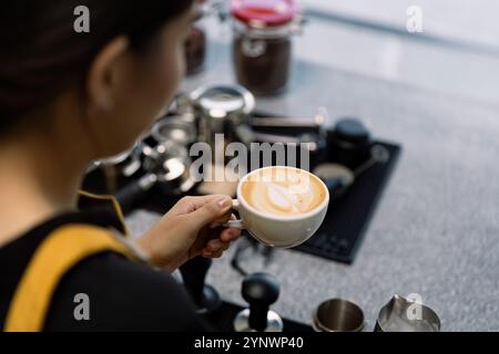 Junger Barista bastelt Latte Art in einem modernen Startup Coffee Shop Stockfoto