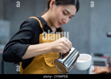 Junger Barista im modernen Coffee Shop bereitet eine frische Tasse Kaffee für Gäste in einer Startup-Umgebung für kleine Unternehmen vor Stockfoto