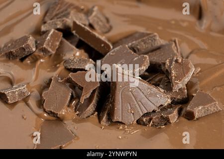 Schokoladenstücke in geschmolzener Milchschokolade. Stockfoto