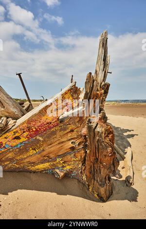 Ein zerstörtes Boot auf Sandflächen am Crow Point, in der Mündung von Taw und Torridge, in der Nähe von Banrnsaple, Devon, Großbritannien. Stockfoto