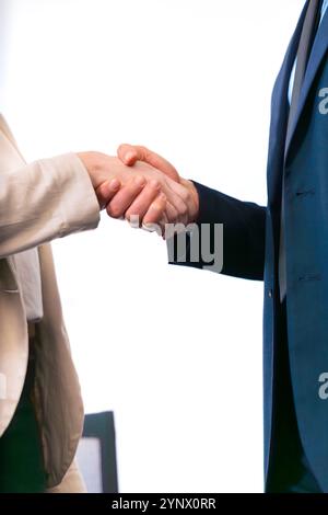 Geschäftsleute schütteln sich die Hände in modernen Büroumgebungen. Vertikal Stockfoto