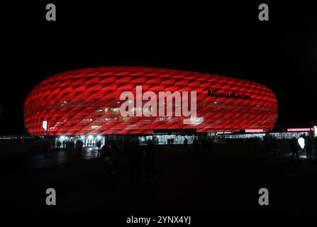 München, Deutschland, 26. November 2024: Fussball, Herren, Champions League, Saison 2024/2025, FC Bayern München - FC Paris Saint-Germain, Allianz Arena, 5.Spieltag hier die Aussenansicht der Allianz Arena, rot beleuchtet, Nacht, Dunkel, FC Bayern München, Heimspielstätte, Fussballstadion Stockfoto