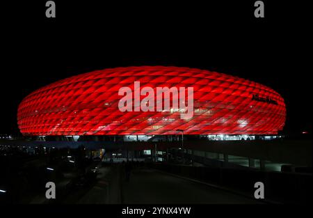 München, Deutschland, 26. November 2024: Fussball, Herren, Champions League, Saison 2024/2025, FC Bayern München - FC Paris Saint-Germain, Allianz Arena, 5.Spieltag hier die Aussenansicht der Allianz Arena, rot beleuchtet, Nacht, Dunkel, FC Bayern München, Heimspielstätte, Fussballstadion Stockfoto