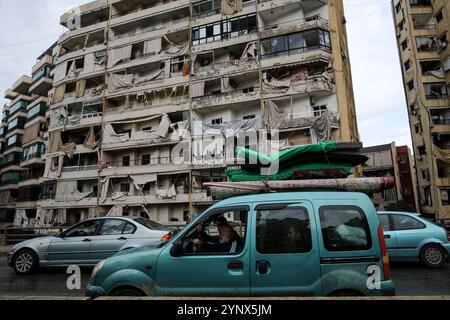 Beirut, Libanon. November 2024. Eine libanesische Familie fährt ein Auto mit Matratzen, als sie in den südlichen Vorort Beiruts zurückkehrt. In den frühen Morgenstunden des 27. November trat ein Waffenstillstand zwischen Israel und der libanesischen Hisbollah-Miliz in Kraft, doch ging ihm bis zum Beginn des Waffenstillstands schwere Explosionen im Gebiet von Beirut voraus. Marwan Naamani//dpa/Alamy Live News Stockfoto