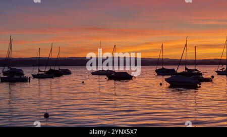 Bodensee Panorama. Abend, Dämmerung, untergehende Sonne, malerische Landschaft, ruhiges Wasser, Boote und Yachten am Dock, schöner Himmel mit Wolken Stockfoto