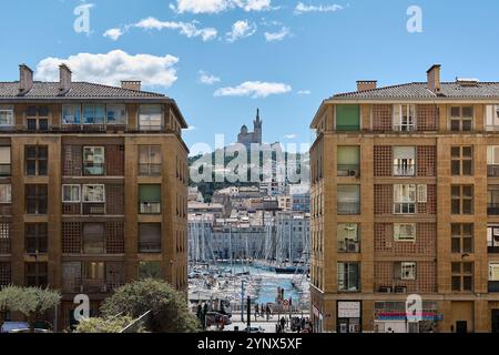 Marseille. Frankreich - 27. November 2024: Der lebhafte Hafen von Marseille mit zahlreichen Segelbooten und der historischen Basilika Notre-Dame de la Garde A Stockfoto