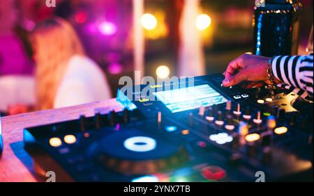 DJ spielt Musik während der Winterfeier in der Cocktailbar - Unterhaltungs- und Clubbingkonzept - Soft Focus auf Disc Jockey Hand Stockfoto