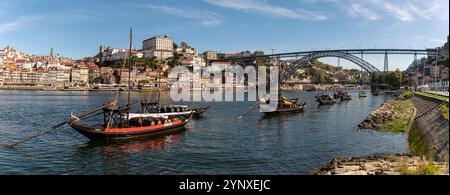 Porto, Portugal - 12. September 2024 : traditionelle Boote gleiten auf dem Fluss Douro in Porto mit einer atemberaubenden Brücke über dem Fluss. Stockfoto