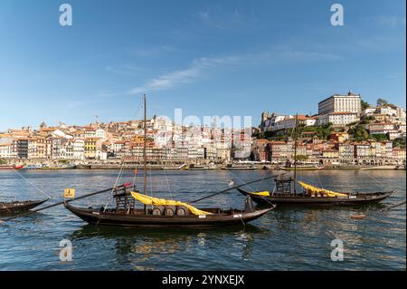 Porto, Portugal - 12. September 2024 : traditionelle Boote gleiten entlang des Flusses Douro mit den bunten Gebäuden von Porto in der Nähe. Stockfoto