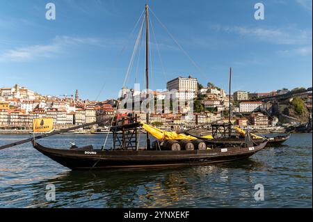 Porto, Portugal - 12. September 2024 : Rabelo-Boote schweben auf dem Fluss Douro mit den historischen Gebäuden von Porto im Hintergrund. Stockfoto