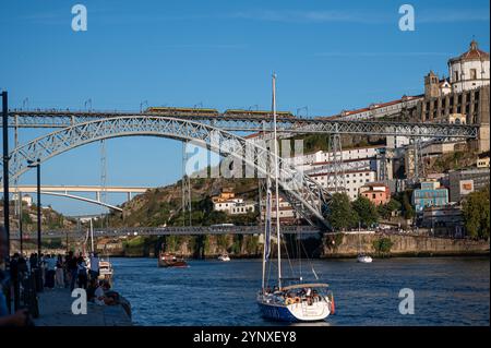 Porto, Portugal - 13. September 2024: Segelboote fahren auf dem Fluss Douro unter der berühmten Brücke Dom Luis I in Porto. Stockfoto