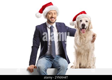 Mann und Hund tragen santa claus Hüte isoliert auf weißem Hintergrund Stockfoto