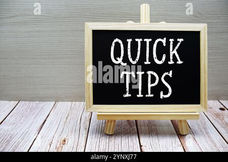 Quick Tips Text geschrieben auf Tafel mit Staffelei auf hölzernem Hintergrund Stockfoto