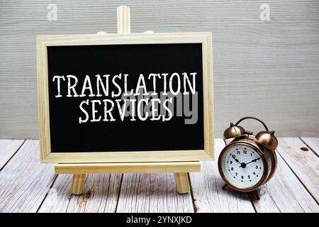 Text auf Tafel geschrieben mit Wecker auf hölzernem Hintergrund Stockfoto