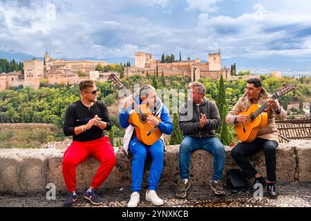 Granada, Spanien, 27. Oktober 2024: Gruppe von Zigeuner-Musikern, die Flamenco-Kunst im berühmten Mirador de San Nicolas mit Blick auf die Alhambra aufführen Stockfoto