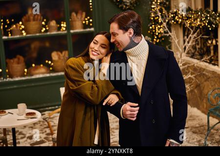 Ein liebevolles Paar genießt die Gesellschaft in einem charmanten Wintercafé, das für die Saison eingerichtet ist. Stockfoto