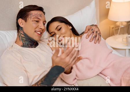 Ein junges Paar lächelt und erzählt Geschichten in einer warmen, intimen Umgebung. Stockfoto