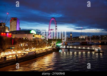 Blick von der Waterloo Bridge in der Abenddämmerung auf das London Eye, die Hungerford Bridge und die Golden Jubilee Bridge und die Houses of Parliament, London, England, Großbritannien Stockfoto