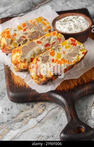 Hühnerleber Eier Gemüseauflauf geschnitten auf Holzbrett auf dem Tisch. Vertikal Stockfoto