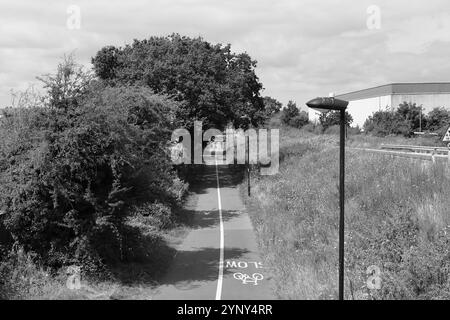 Gosport, Hampshire, England. 4. August 2024. Schwarz-weiß-Ansicht des Radweges nach Fareham, von der Brücke auf der Rowner Road aus gesehen. Stockfoto