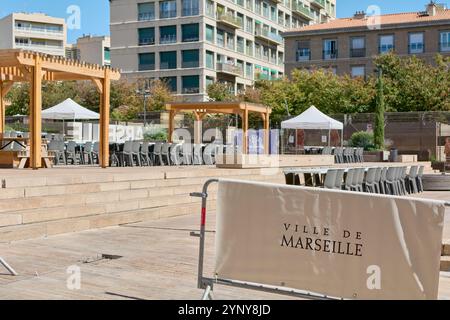 Marseille. Frankreich - 27. November 2024: Ein zeitgenössischer urbaner Raum in Marseille mit hölzernen Pergolen, zahlreichen Stühlen und umliegenden Gebäuden, ideal Stockfoto