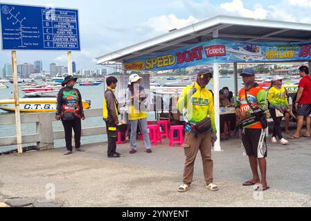 Pattaya, Thailand - 9. Oktober 2024: Bali Hai zwei thailändische Männer in bunten Kleidern posierten vor einem Outdoor-Shop, der Tickets für Schnellboote verkauft Stockfoto