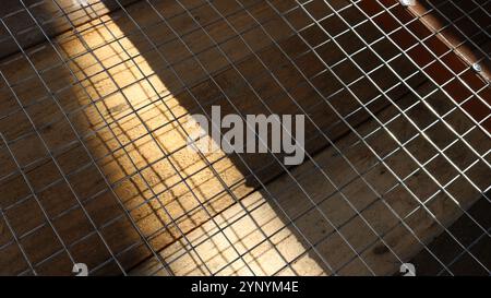 Metallpflaster über Holzdielen im Spiel von Licht und Schatten als abstrakter kombinierter multistrukturierter volumetrischer Hintergrund Stockfoto
