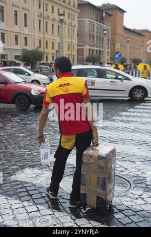 VATIKANSTADT, VATIKAN, 18. OKTOBER 2016: Unbekannter DHL-Kurier mit großem Paket in der Nähe des petersdoms Stockfoto