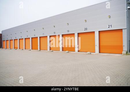 Außenbereich eines gewerblichen Lagers mit orangefarbenen Rolltüren Stockfoto