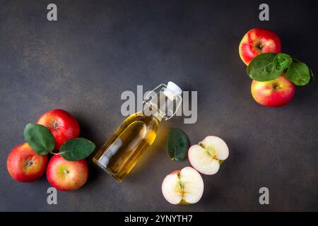 Apfelessig in der Glasflasche mit Kork, einem frischen roten Apfel Stockfoto