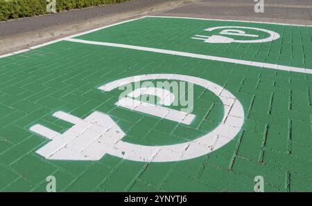 Parkplatz mit Ladesymbol für Elektroautos Stockfoto