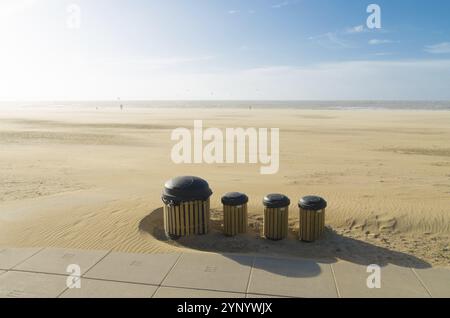 Reihen Sie Staubbehälter an einem trostlosen, windigen Nordseestrand in den niederlanden auf Stockfoto